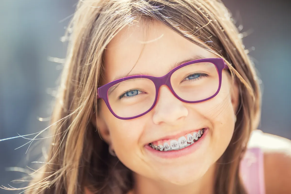 Smiling girl with glasses and braces